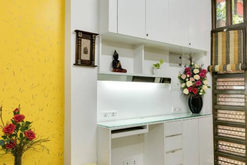a kitchen with white cabinets and flowers on the counter at Moydom Nice & Cosy Private 1 BHK Apartment OPP NFC market in New Delhi