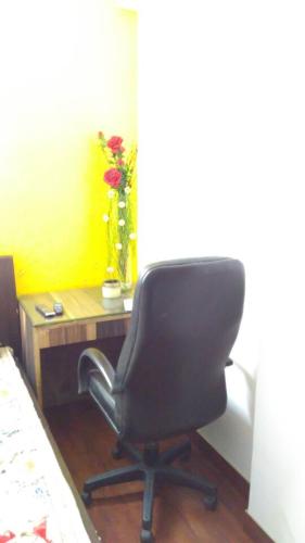 a desk with a chair and a vase with flowers at Moydom Nice & Cosy Private 1 BHK Apartment OPP NFC market in New Delhi