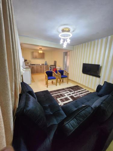 uma sala de estar com um sofá e uma televisão em Zuri homes 1 em Kagio