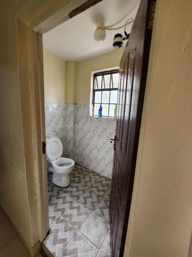 uma casa de banho com um WC e uma janela em Zuri homes 1 em Kagio