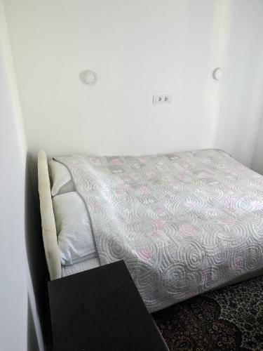 a small bed in a room with a book at Stara etno kuća Radonjić in Guča