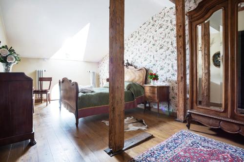 a bedroom with a bed and a mirror at Burbiskio dvaras in Anykščiai