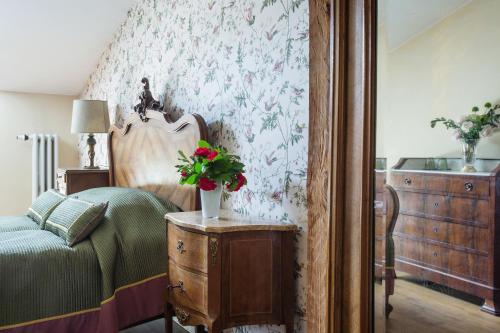 a bedroom with a bed and a table with flowers on it at Burbiskio dvaras in Anykščiai
