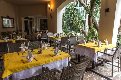 a restaurant with tables and chairs with yellow tablecloths at Tunisia Lodge in Hammamet