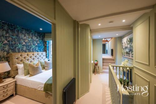 a bedroom with a large bed and a staircase at Riverside House - A Truly Unique Stay For 8 Guests in Marlow