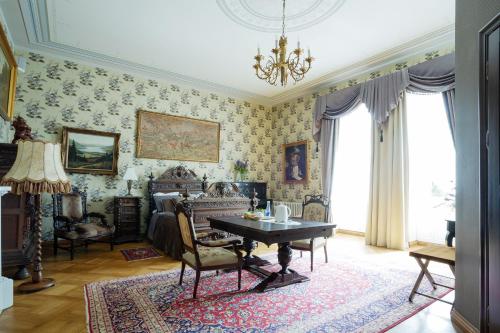 a living room with a table in a room with wallpaper at Burbiskio dvaras in Anykščiai