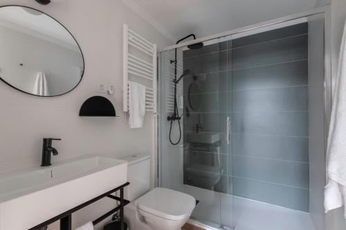a bathroom with a toilet and a sink and a mirror at B48 Bilbao Abando in Bilbao