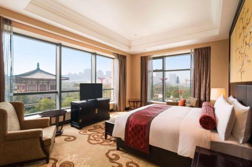 a hotel room with a bed and a large window at Wyndham Grand Xi'an Residence in Xi'an