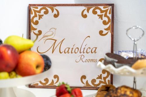 une pancarte devant une assiette de fruits dans l'établissement Maiolica Rooms, à Raguse