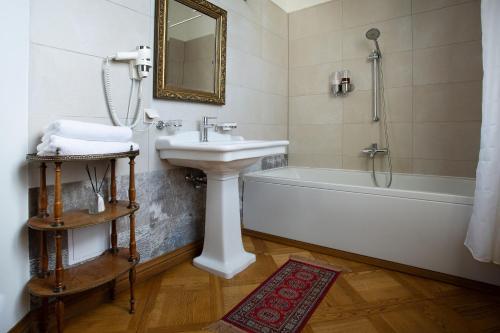 a bathroom with a sink and a bath tub and a sink at Burbiskio dvaras in Anykščiai