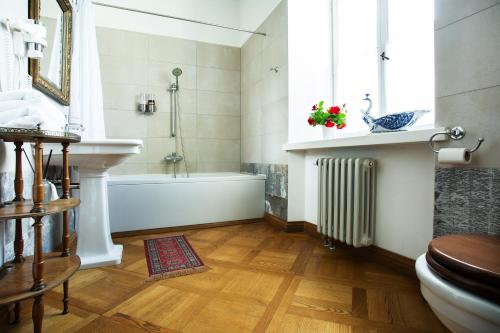 a bathroom with a tub and a sink and a window at Burbiskio dvaras in Anykščiai