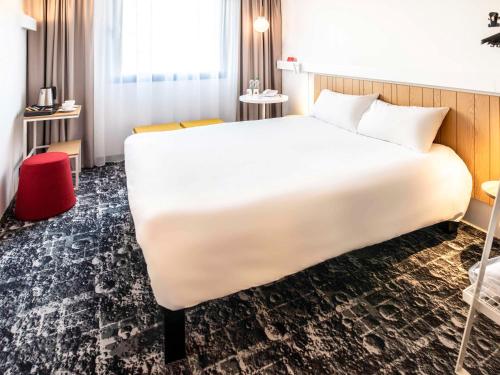 a large white bed in a hotel room at Hotel Ibis Krakow Centrum in Kraków