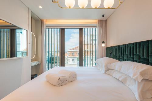 a bedroom with a white bed with towels on it at LUSTER Hotel in Lisbon
