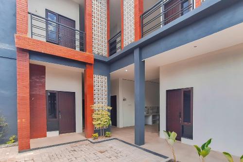 eine Außenansicht eines Hauses mit roten und blauen Säulen in der Unterkunft Urbanview Hotel Griya Menteng Palangkaraya by RedDoorz in Tumbangrungan