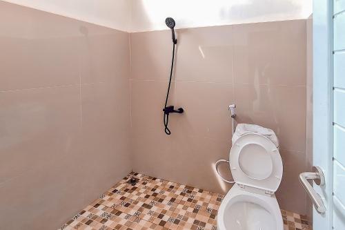 TumbangrunganにあるUrbanview Hotel Griya Menteng Palangkaraya by RedDoorzのバスルーム(トイレ、壁にブロードライヤー付)