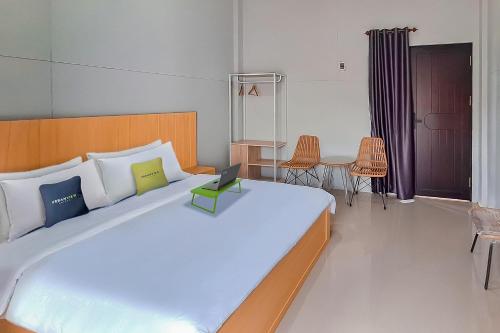 TumbangrunganにあるUrbanview Hotel Griya Menteng Palangkaraya by RedDoorzのベッドルーム1室(大型ベッド1台、ノートパソコン付)