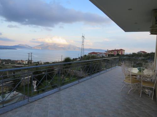a balcony with a view of the water and mountains at Villa Christine - Maisonettes with fireplace in Aliveri
