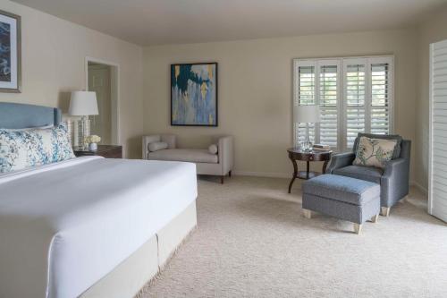 een slaapkamer met een groot wit bed en 2 stoelen bij Hyatt Regency Grand Cypress Resort in Orlando