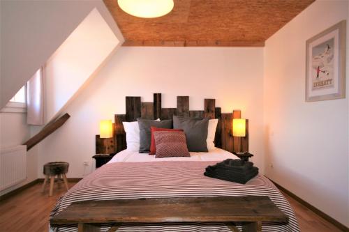 une chambre avec un grand lit avec une tête de lit en bois dans l'établissement La ferme de Georges Apt 1 à 6 pers, à Bischholtz
