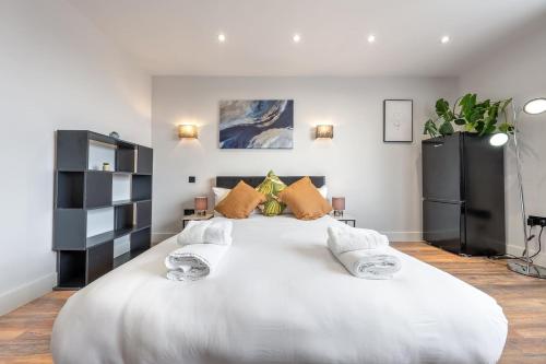 een groot wit bed met 2 kussens erop bij 3 West London Brand New Loft in Londen