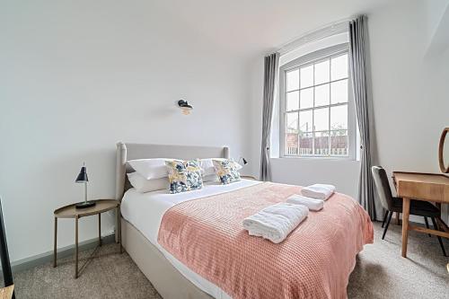 a bedroom with a bed with a desk and a window at County House Escape - courtyard & free parking in York