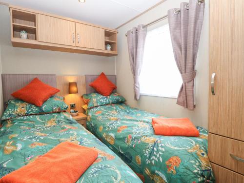 2 nebeneinander sitzende Betten in einem Schlafzimmer in der Unterkunft Stanley's Lodge, Foxburrow Hang in Great Yarmouth