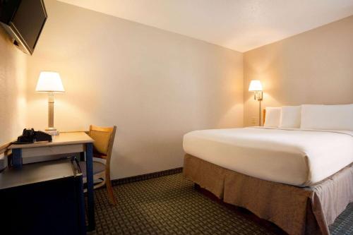 a hotel room with a large bed and a desk at Travelodge by Wyndham Edgemont in Edgemont