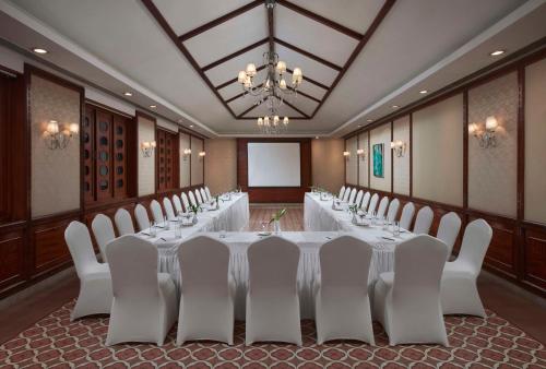 a conference room with a long table and white chairs at Radisson Blu Resort, Goa in Cavelossim