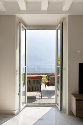 a living room with a sliding glass door leading to a patio at Maison MUSA at Vita B in Lenno