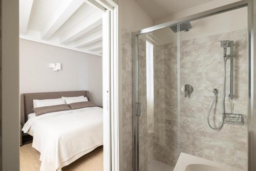 a bathroom with a shower and a bed in a room at Maison MUSA at Vita B in Lenno