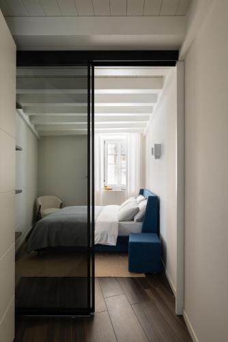 a bedroom with a bed and a blue chair at Maison MUSA at Vita B in Lenno