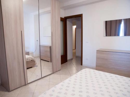 um quarto com um espelho, uma cama e uma cómoda em Trilocale vicino al mare em Piombino