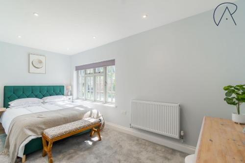 a bedroom with a large bed with a green headboard at Chic Home, Hot Tub, Hydro Pool & Gym - 15 Mins to Windsor in Warfield