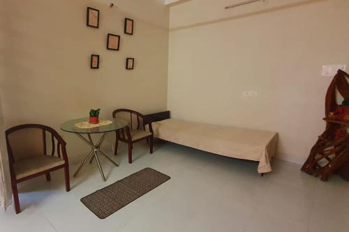 a room with a bed and a table and chairs at Mimo's in Guwahati