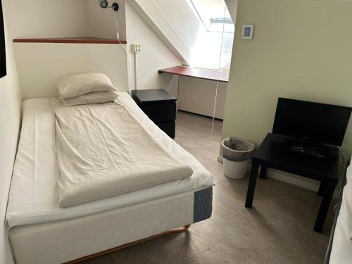 a hospital room with a bed and a desk at Hotel Kupolen in Borlänge