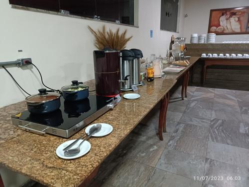 eine Theke mit Töpfen und Pfannen auf dem Herd in der Unterkunft Hotel Oscar Blue Montes Claros in Montes Claros