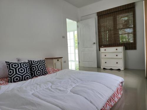 um quarto branco com uma cama grande e uma cómoda em Minimal homey 3BR near Mee Chok plaza em Chiang Mai