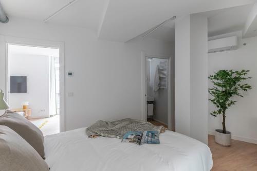 a white room with a bed with two books on it at B48 Bilbao Abando in Bilbao