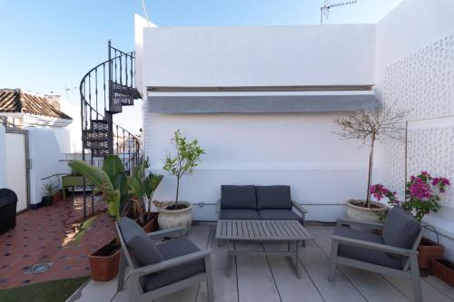 eine Terrasse mit 2 Stühlen und einem Tisch und einigen Pflanzen in der Unterkunft The Terrace, dúplex con terraza privada in Sevilla