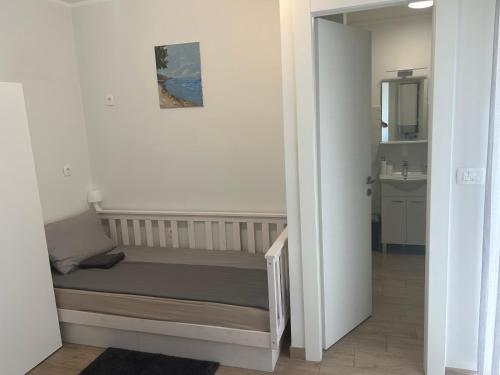 - une petite chambre avec un lit et un miroir dans l'établissement Sea Touch Apartment, à Rijeka