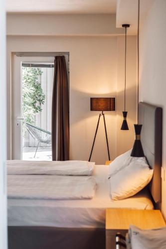 two beds in a room with a window at Ah Porticcioli Boutique Apartments in San Felice del Benaco
