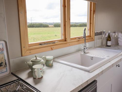 um balcão de cozinha com um lavatório e uma janela em Shepherds Hut em Scunthorpe