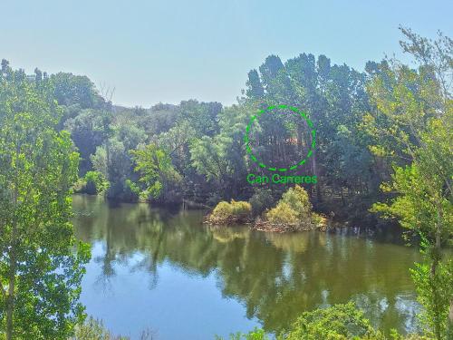 a view of a river with trees in the background at Can Carreres - Un lloc on desconnectar en família in El Pasteral