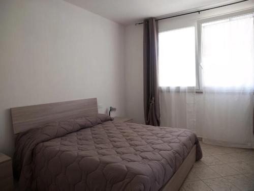 a bedroom with a bed and a large window at Bilocale vicino al mare in Piombino