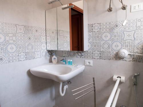 uma casa de banho com um lavatório e um espelho em Bilocale vicino al mare em Piombino