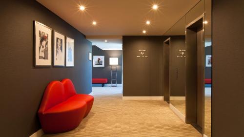 a hallway with a red chair in a room at Lutecia Smart Design Hotel in Lisbon