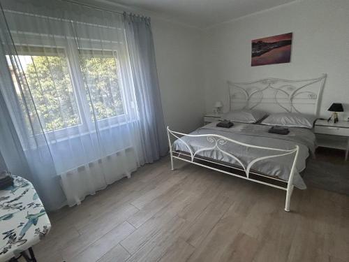 1 Schlafzimmer mit einem weißen Bett und 2 Fenstern in der Unterkunft Sea Touch Apartment in Rijeka