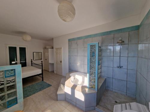 a large bathroom with a shower and a sink at Olive Villa in Episkopianá