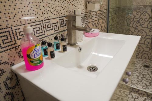 a bathroom sink with a bottle of cleaning agent on it at Chinor Garden Hotel - Free Airport Pick-up and Drop-Off in Tashkent