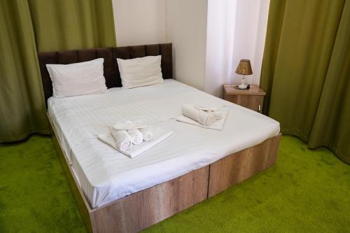 a bed with white sheets and towels on it at Chinor Garden Hotel - Free Airport Pick-up and Drop-Off in Tashkent